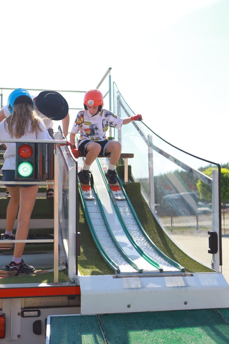Kinder beim Skispringen auf einer kleinen Matte