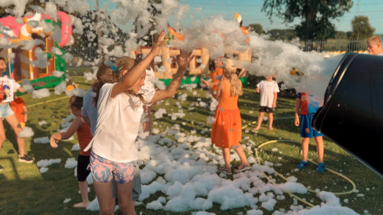 Kinder haben Spaß bei einer Schaumparty im Freien